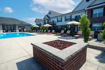 A pool area with a fire pit in the middle of it.